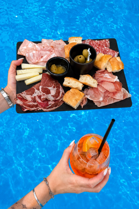 Tagliere di salumi e formaggi con Spritz a bordo piscina